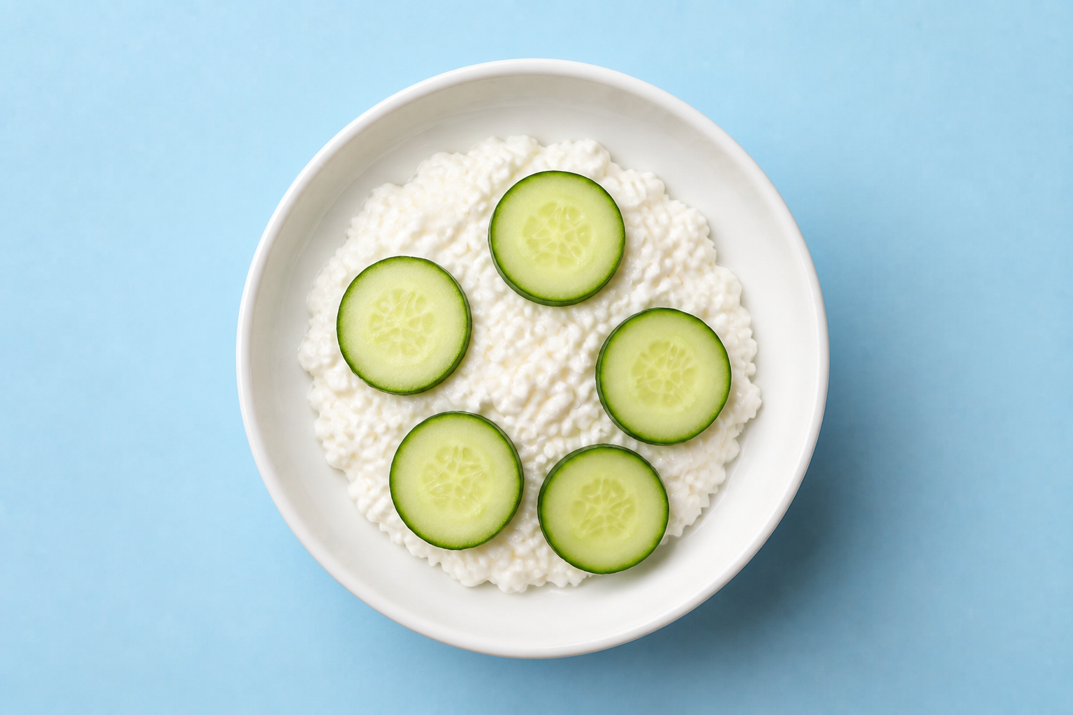 Small bowl of cottage cheese with cucumber